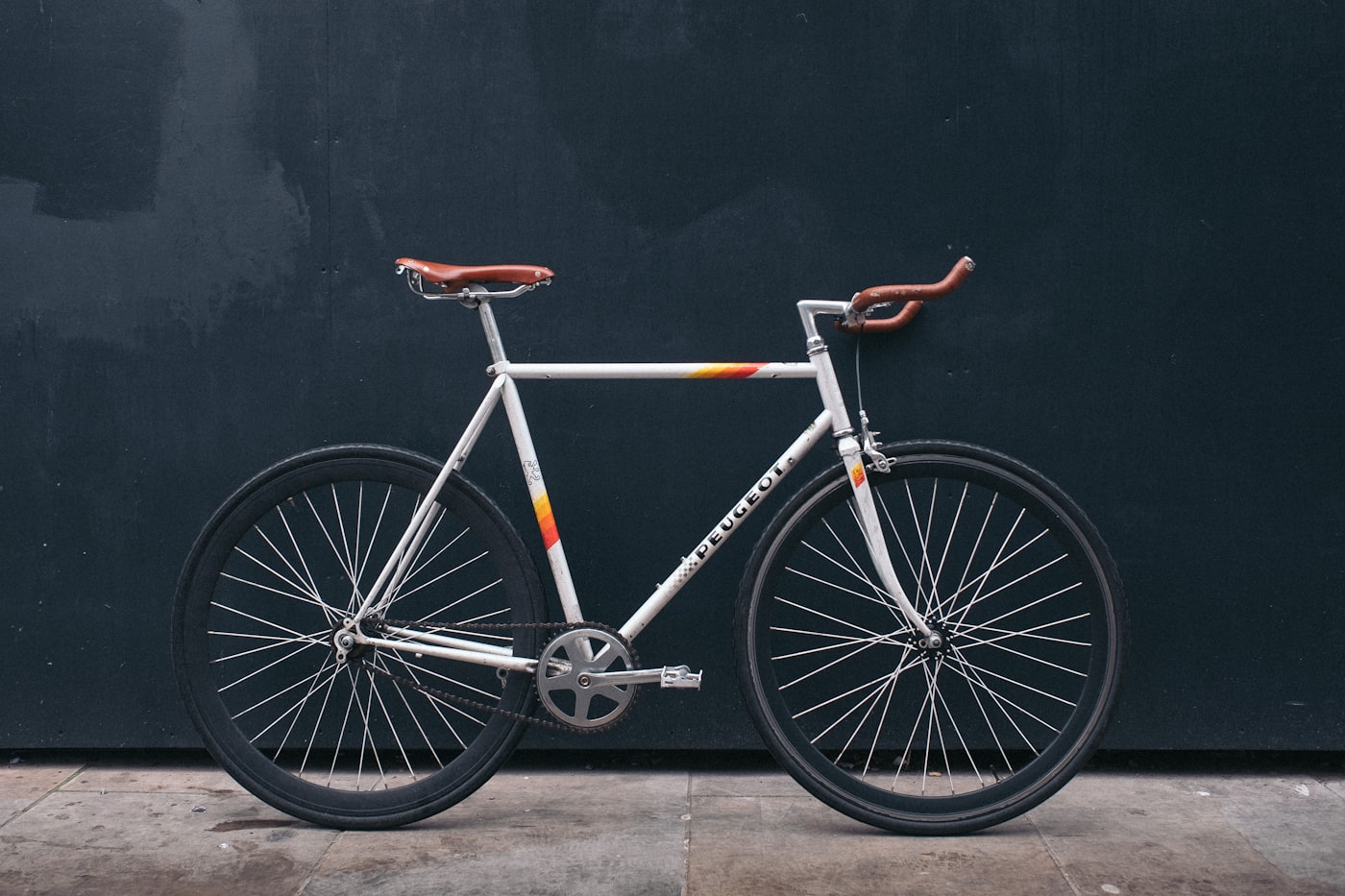 Klassisches Rennrad mit Ledersattel vor dunkler Wand
